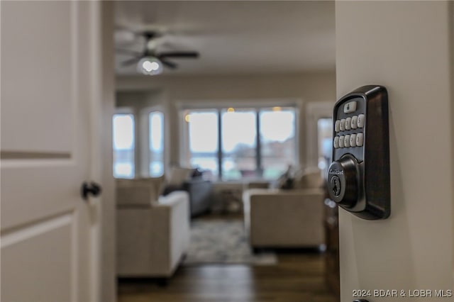 living room featuring dark wood-type flooring and ceiling fan