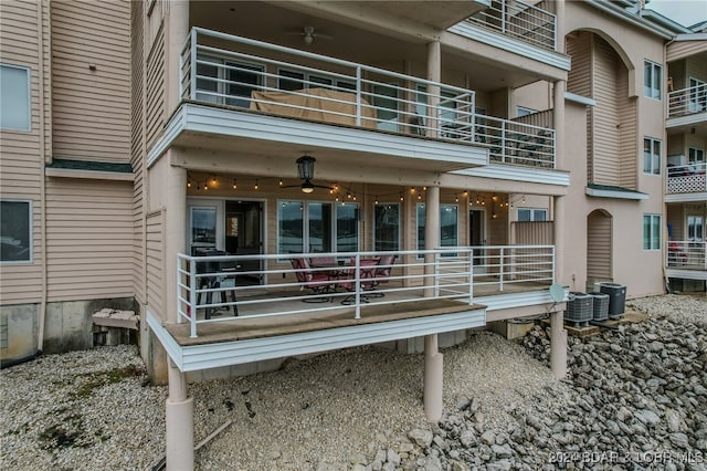 back of property featuring central AC unit and a balcony