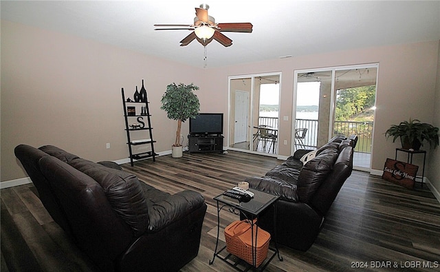 living room featuring dark wood-type flooring and ceiling fan