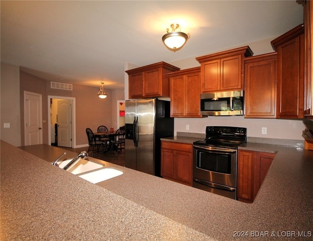 kitchen with sink, decorative light fixtures, and appliances with stainless steel finishes