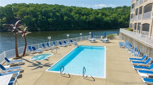 view of swimming pool with a patio and a water view