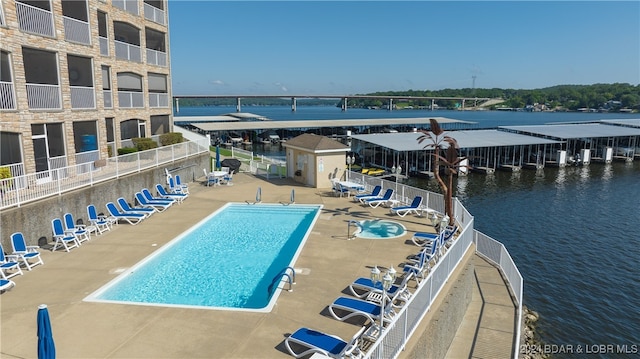 view of swimming pool featuring a patio and a water view