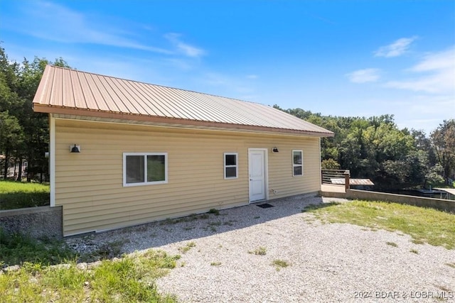 back of property featuring metal roof