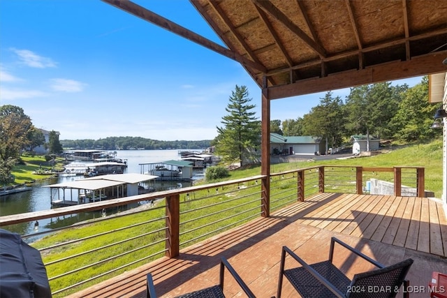 wooden deck with a water view and a yard