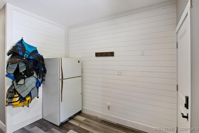 kitchen with wooden walls, dark hardwood / wood-style floors, and white refrigerator