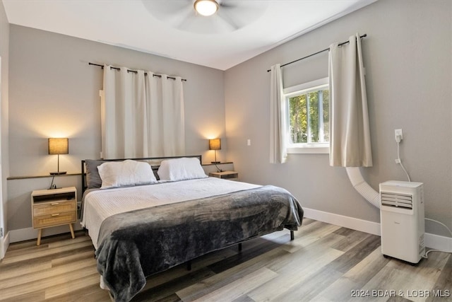 bedroom featuring a ceiling fan, light wood-type flooring, and baseboards