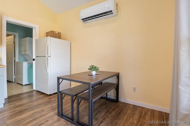 dining space with baseboards, a wall mounted air conditioner, wood finished floors, and stacked washer / drying machine