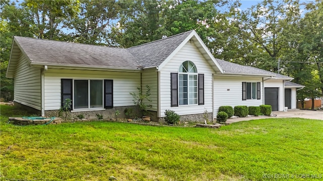 single story home with a garage and a front lawn