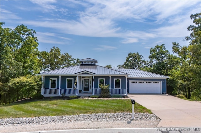 view of front of house with a garage, a front lawn, and a porch