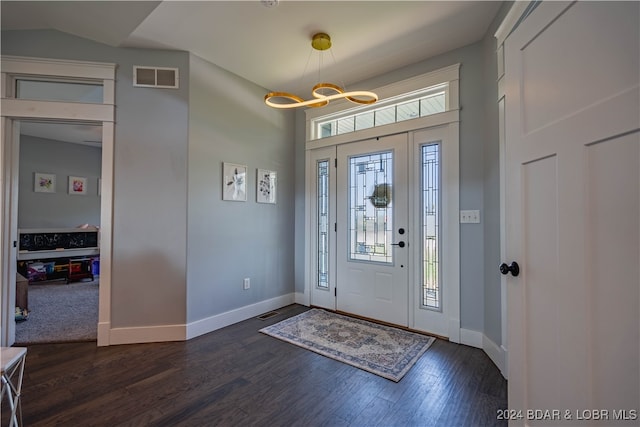 entrance foyer featuring an inviting chandelier, dark hardwood / wood-style flooring, and vaulted ceiling