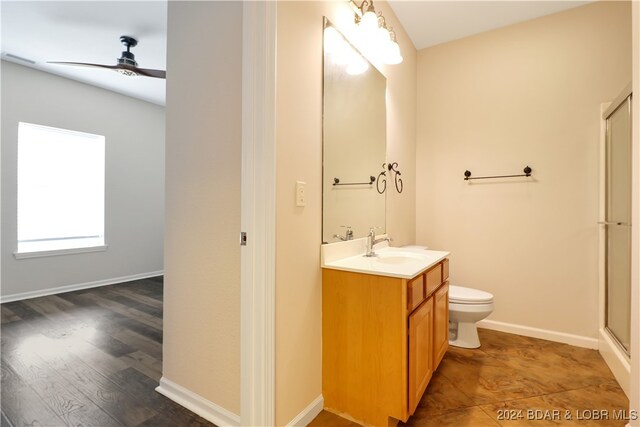 bathroom featuring hardwood / wood-style floors, walk in shower, toilet, ceiling fan, and vanity