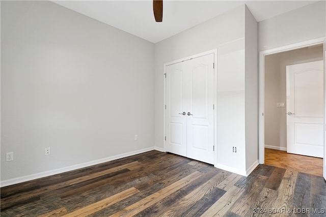 unfurnished bedroom with a closet, ceiling fan, and dark hardwood / wood-style floors