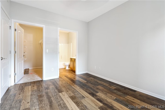 unfurnished bedroom with dark wood-type flooring and ensuite bath