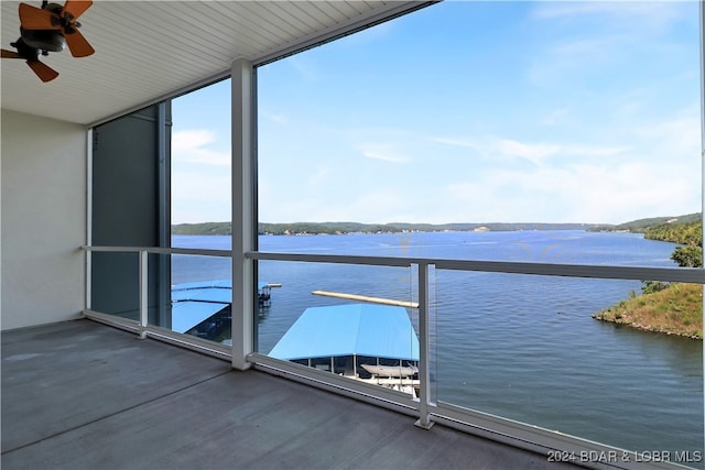 balcony with ceiling fan and a water view