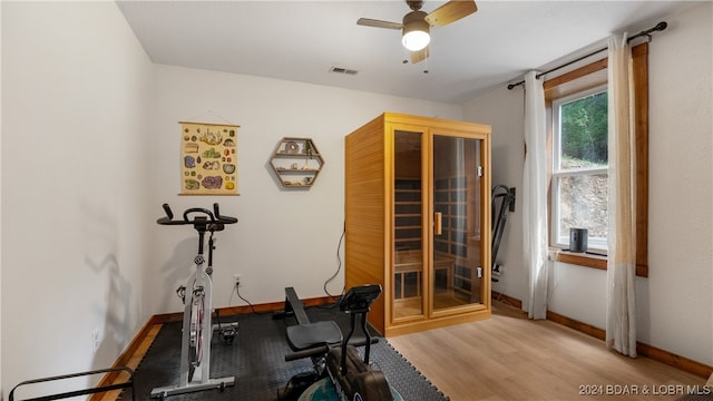 workout room featuring ceiling fan and light hardwood / wood-style flooring