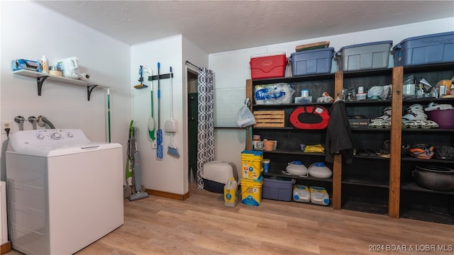 washroom with washer / clothes dryer, light hardwood / wood-style floors, and a textured ceiling