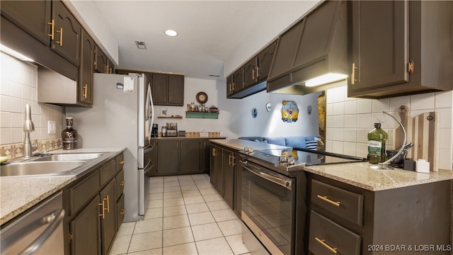 kitchen featuring appliances with stainless steel finishes, dark brown cabinets, and backsplash