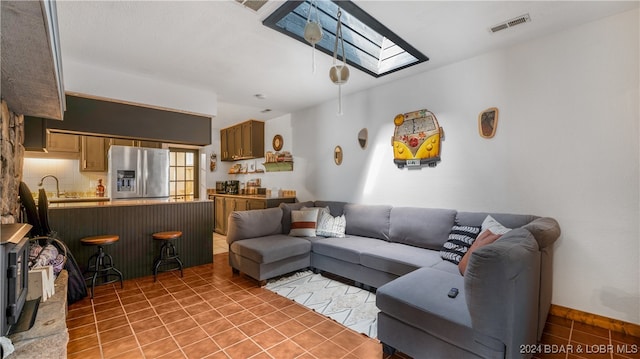 tiled living room featuring a skylight and sink