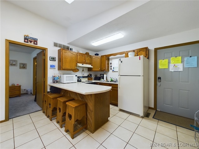 kitchen with a breakfast bar, white appliances, kitchen peninsula, and light tile patterned floors