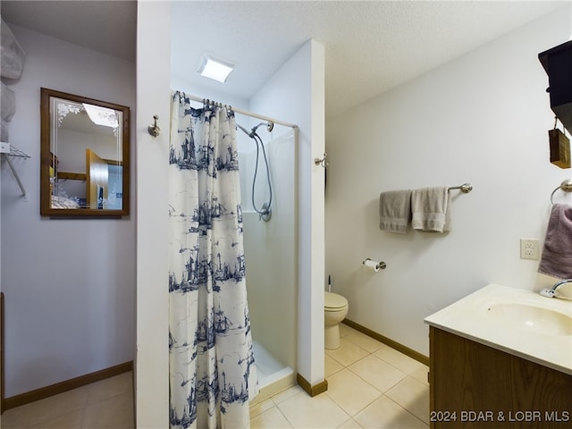 bathroom with a textured ceiling, vanity, toilet, and walk in shower