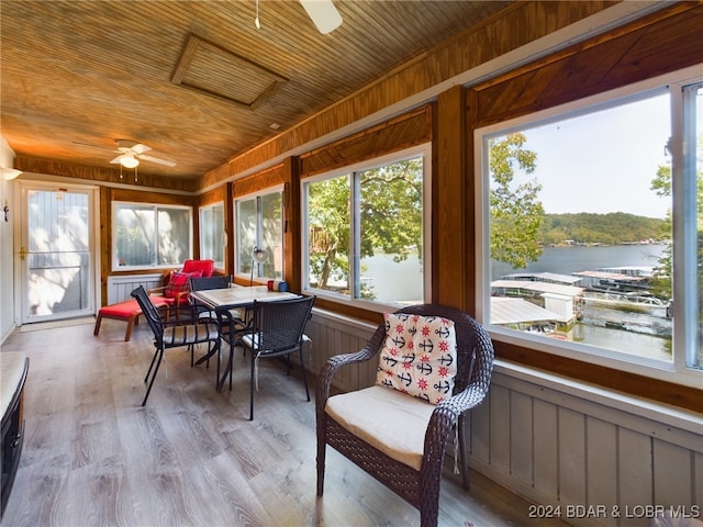 sunroom / solarium with ceiling fan, a water view, and wooden ceiling