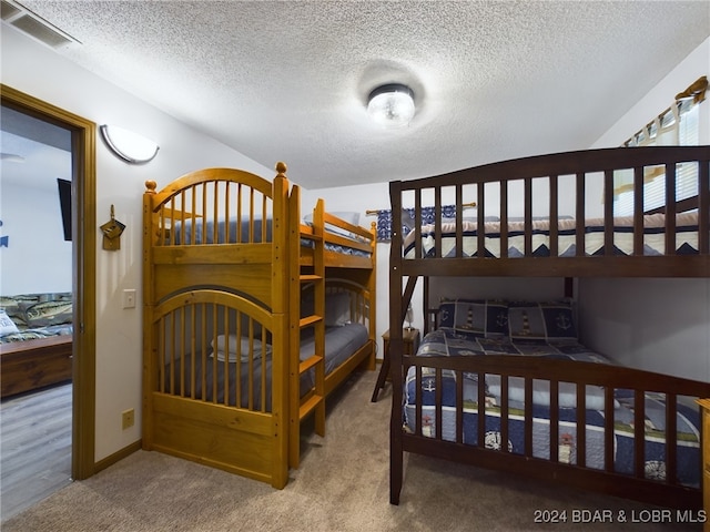 bedroom featuring carpet flooring and a textured ceiling