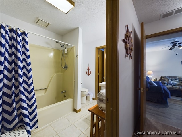 bathroom with tile patterned floors, ceiling fan, toilet, a textured ceiling, and shower / tub combo