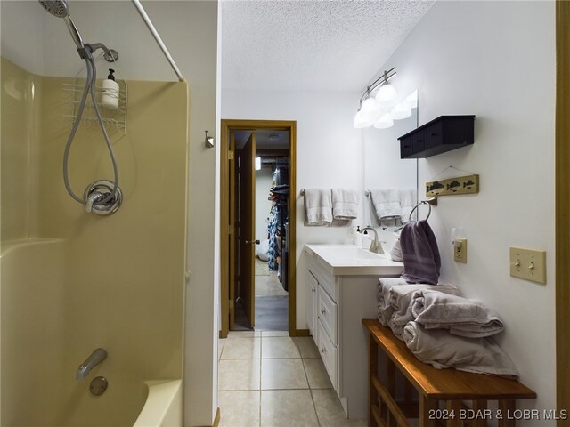 bathroom with tile patterned floors, vanity, shower / bath combination, and a textured ceiling