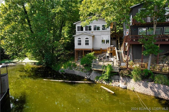 back of house featuring a deck with water view