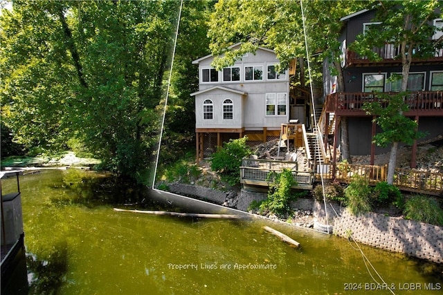 back of property with a deck with water view