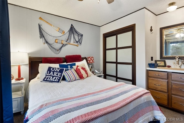 carpeted bedroom with a textured ceiling and ceiling fan