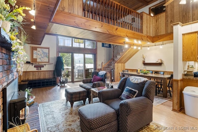 living room with wood ceiling, a towering ceiling, and wood-type flooring