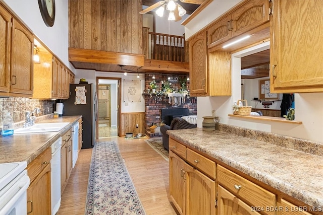 kitchen with backsplash, ceiling fan, light wood-type flooring, sink, and white appliances