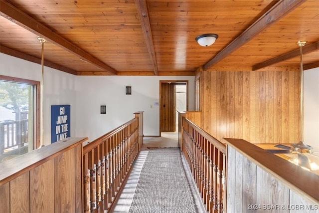 hallway featuring beamed ceiling, wooden walls, and wooden ceiling