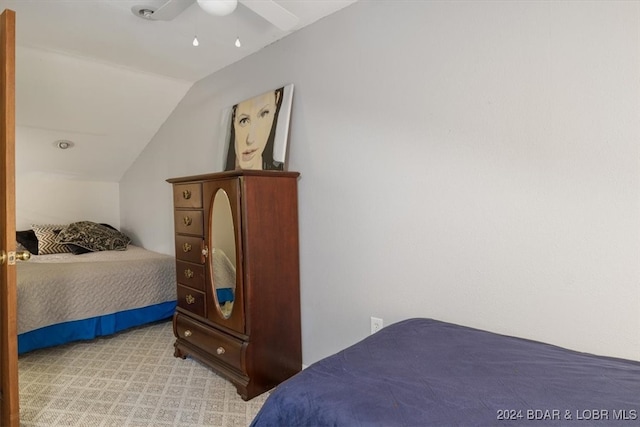 bedroom with ceiling fan, vaulted ceiling, and light colored carpet