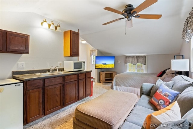 kitchen featuring lofted ceiling, ceiling fan, sink, light colored carpet, and white appliances