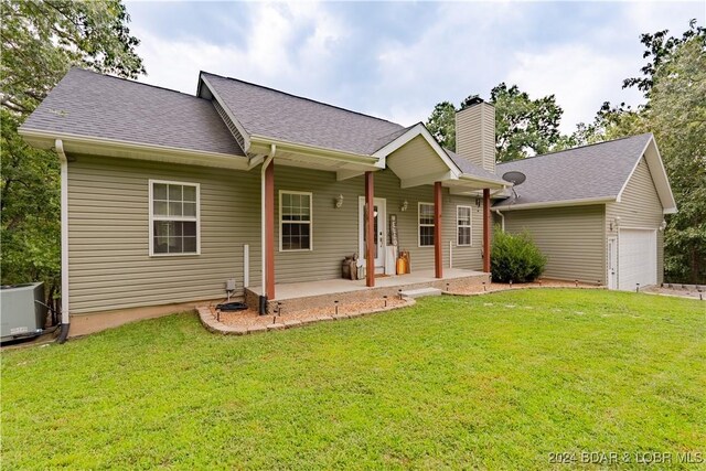 single story home featuring central AC, a front lawn, a porch, and a garage