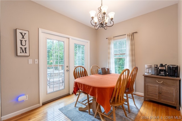 dining area featuring light hardwood / wood-style flooring, plenty of natural light, and an inviting chandelier