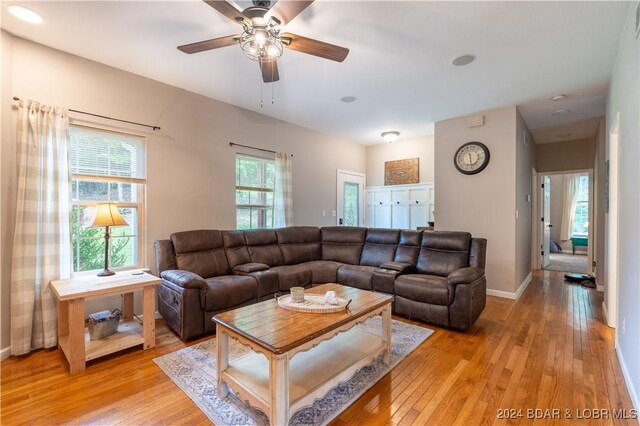 living room with ceiling fan and light hardwood / wood-style flooring