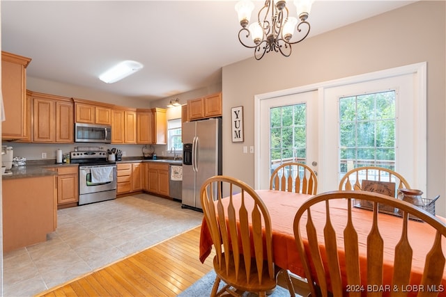 kitchen featuring a notable chandelier, stainless steel appliances, light hardwood / wood-style floors, and a healthy amount of sunlight