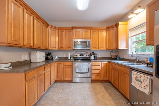 kitchen featuring appliances with stainless steel finishes, light tile patterned floors, and sink