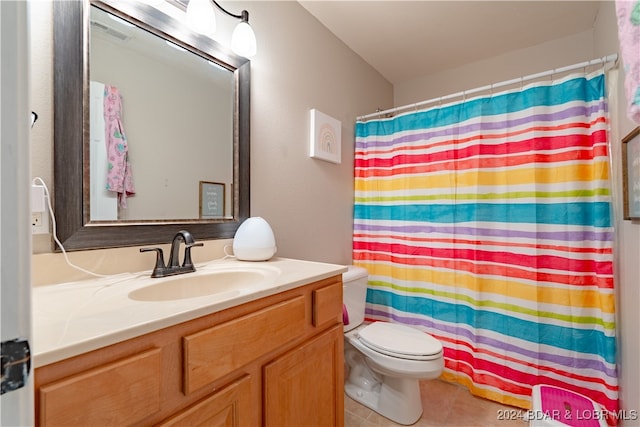 bathroom featuring a shower with shower curtain, vanity, toilet, and tile patterned floors