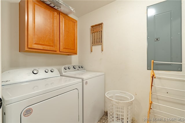 laundry room with cabinets, electric panel, and washer and clothes dryer