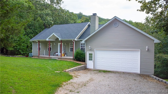 view of front of home with a garage, a front lawn, and a porch