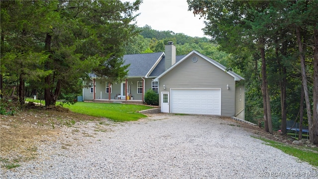 view of front of home featuring a garage, a porch, and a front lawn