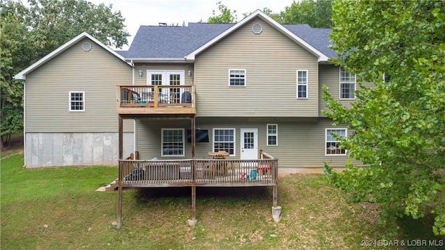 rear view of property featuring a lawn and a wooden deck