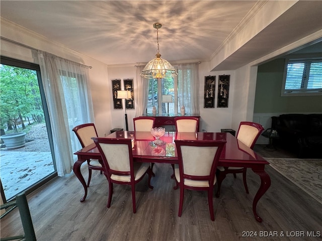 dining area with crown molding, a chandelier, and wood-type flooring