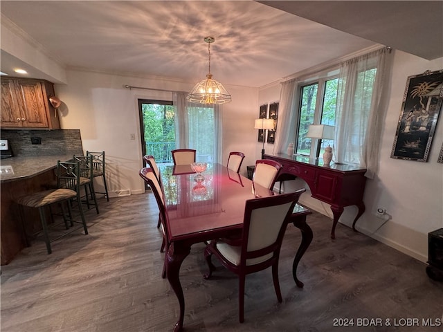 dining area featuring a notable chandelier, crown molding, and dark hardwood / wood-style floors