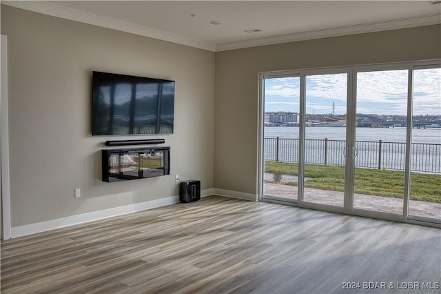 unfurnished living room with hardwood / wood-style flooring and ornamental molding