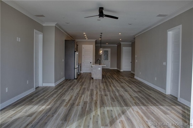 unfurnished living room featuring sink, ornamental molding, ceiling fan, and light wood-type flooring